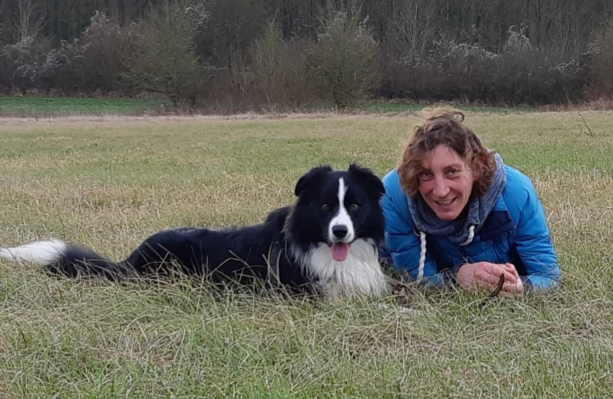 Portret vrijwilliger Annemiek Poorterman Bibliotheek Voorlees Express ligt in het gras met een hond. 