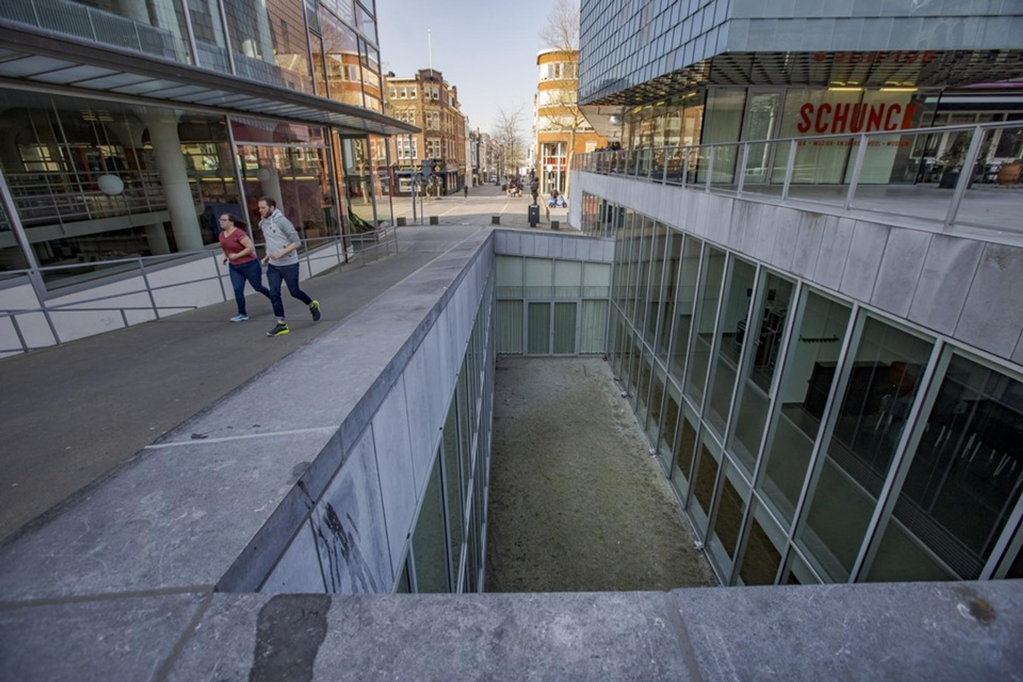 SCHUNCK Glaspaleis Patio, twee mensen hardlopen buiten. 