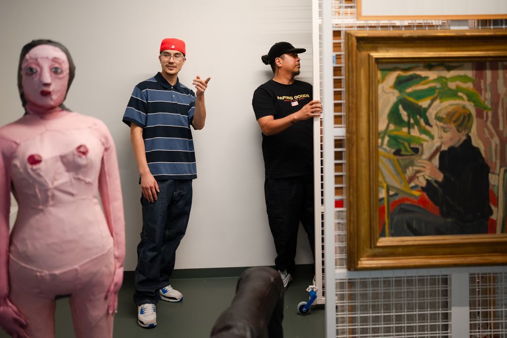 Deelnemer en coach van Life Cipher kiezen werken uit de rekken in het kunstdepot.