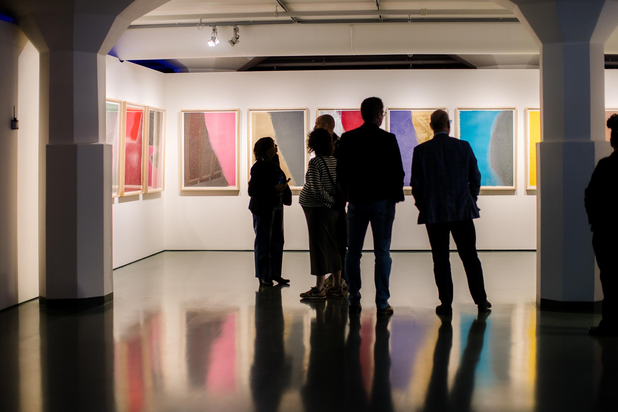 Bezoekers kijken naar zeefdrukken van Andy Warhol in het museum. 