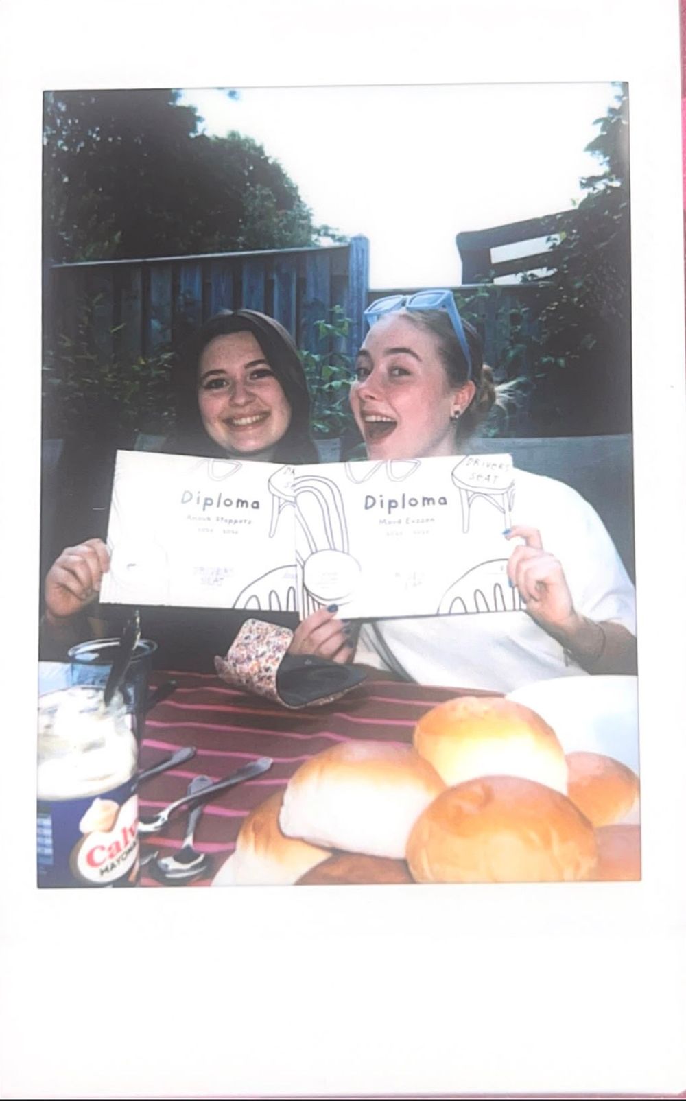 Twee DS-ers met hun diploma op een polaroidfoto