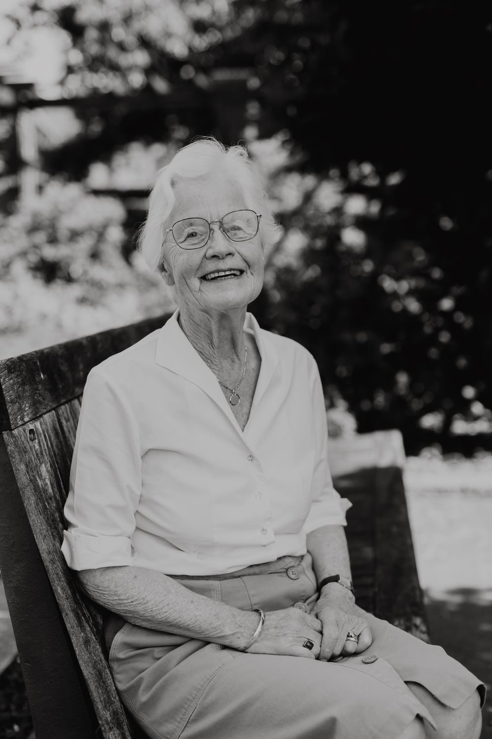 Zwart-witportret van Irene Borghans, zittend, lachtend en recht vooruit kijkend.