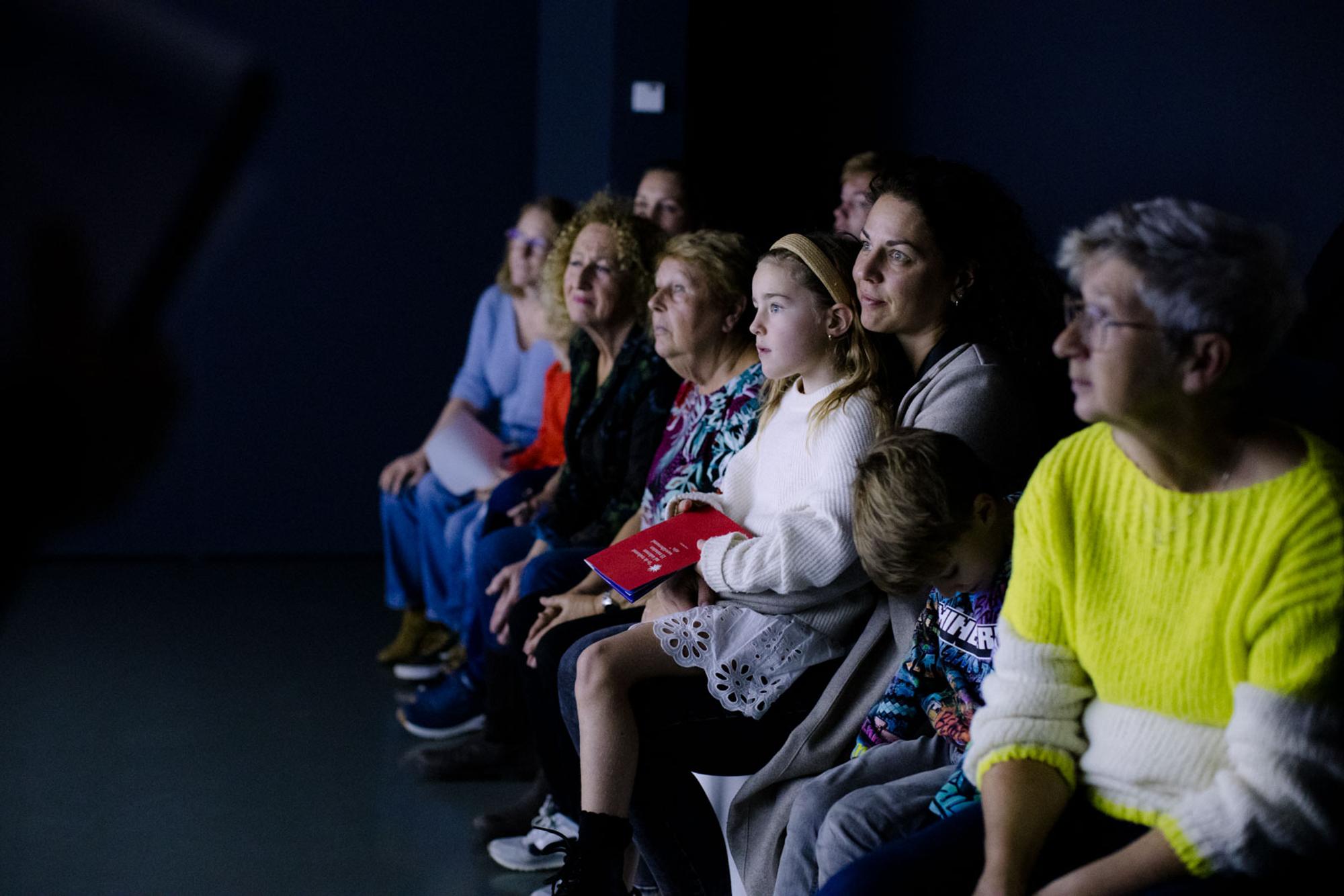 Bezoekers in donkere ruimte kijken naar werk van Andy Warhol.