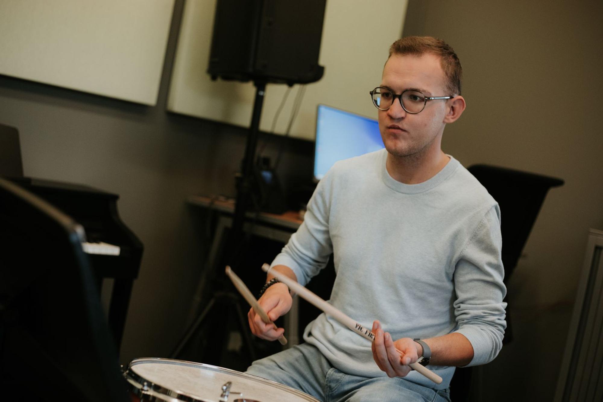 Jonge man speelt op een trommel.