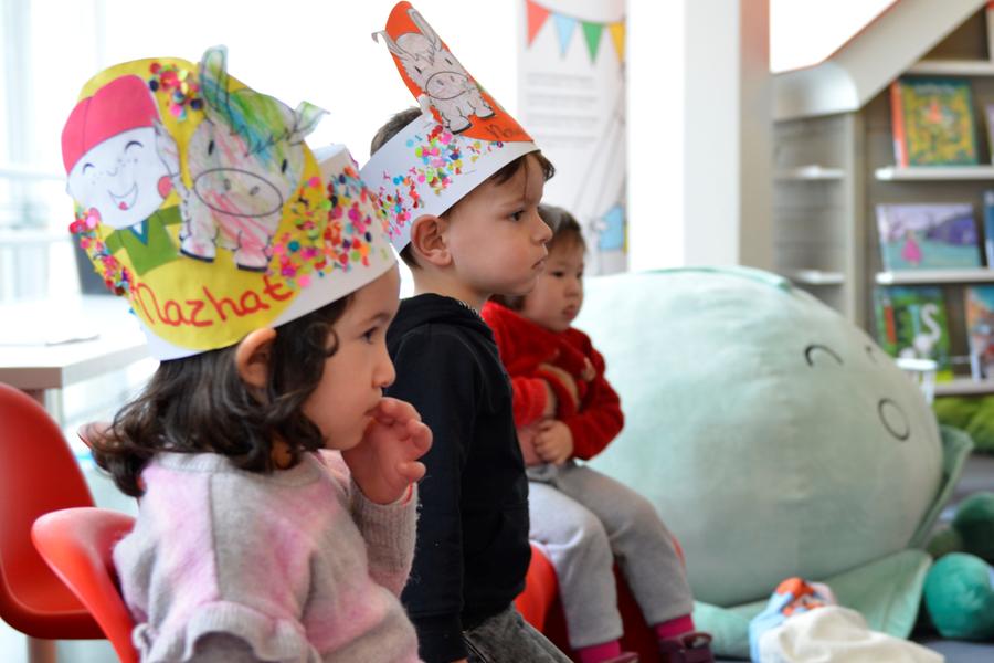 Kinderen met geknutselde kronen zitten in een kring. 