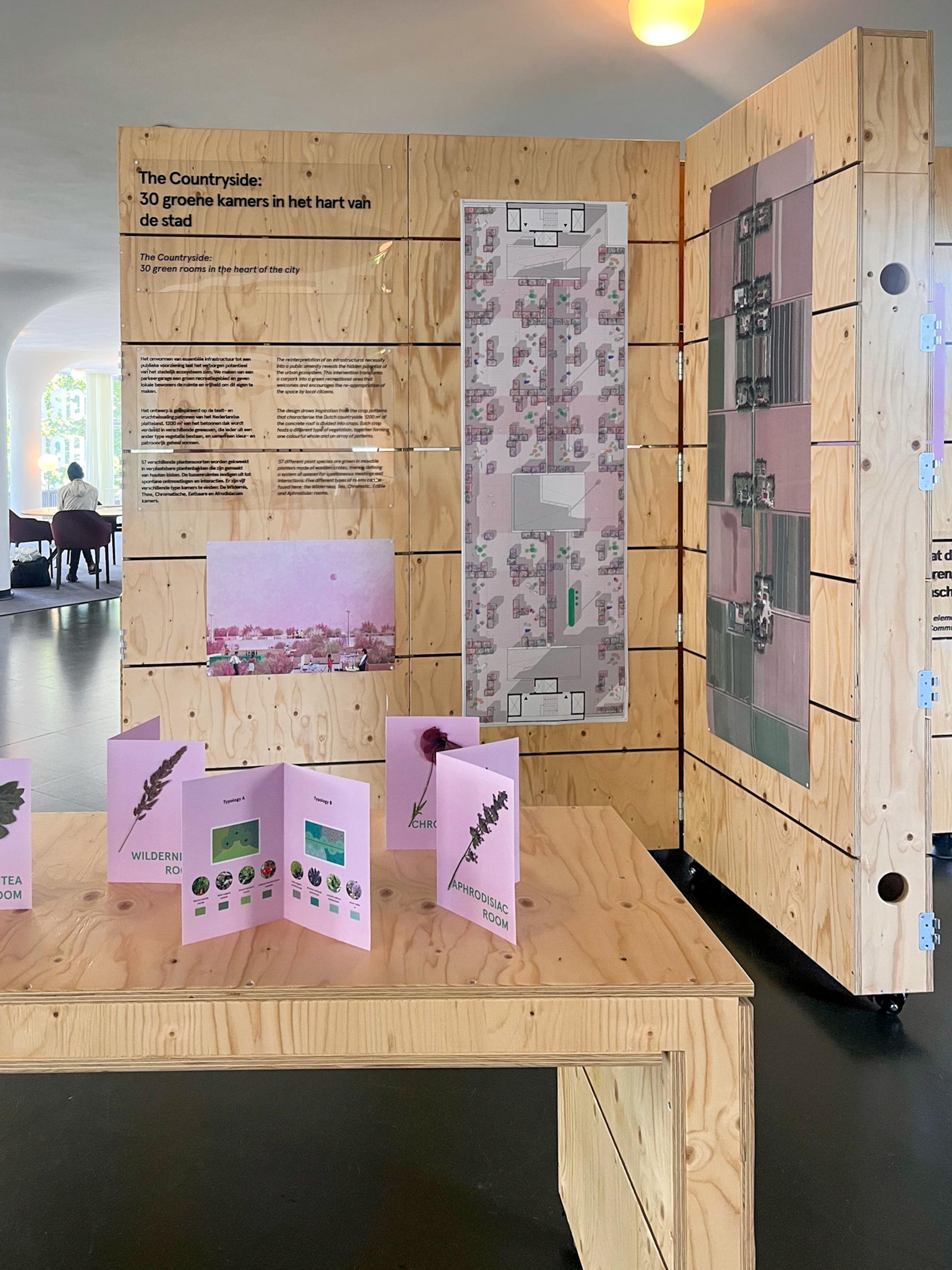 SCHUNCK Dreaming out loud selvatico 2022 Houten presentatie-meubel waar roze kaartjes met afbeeldingen en posters op gepresenteerd staan.