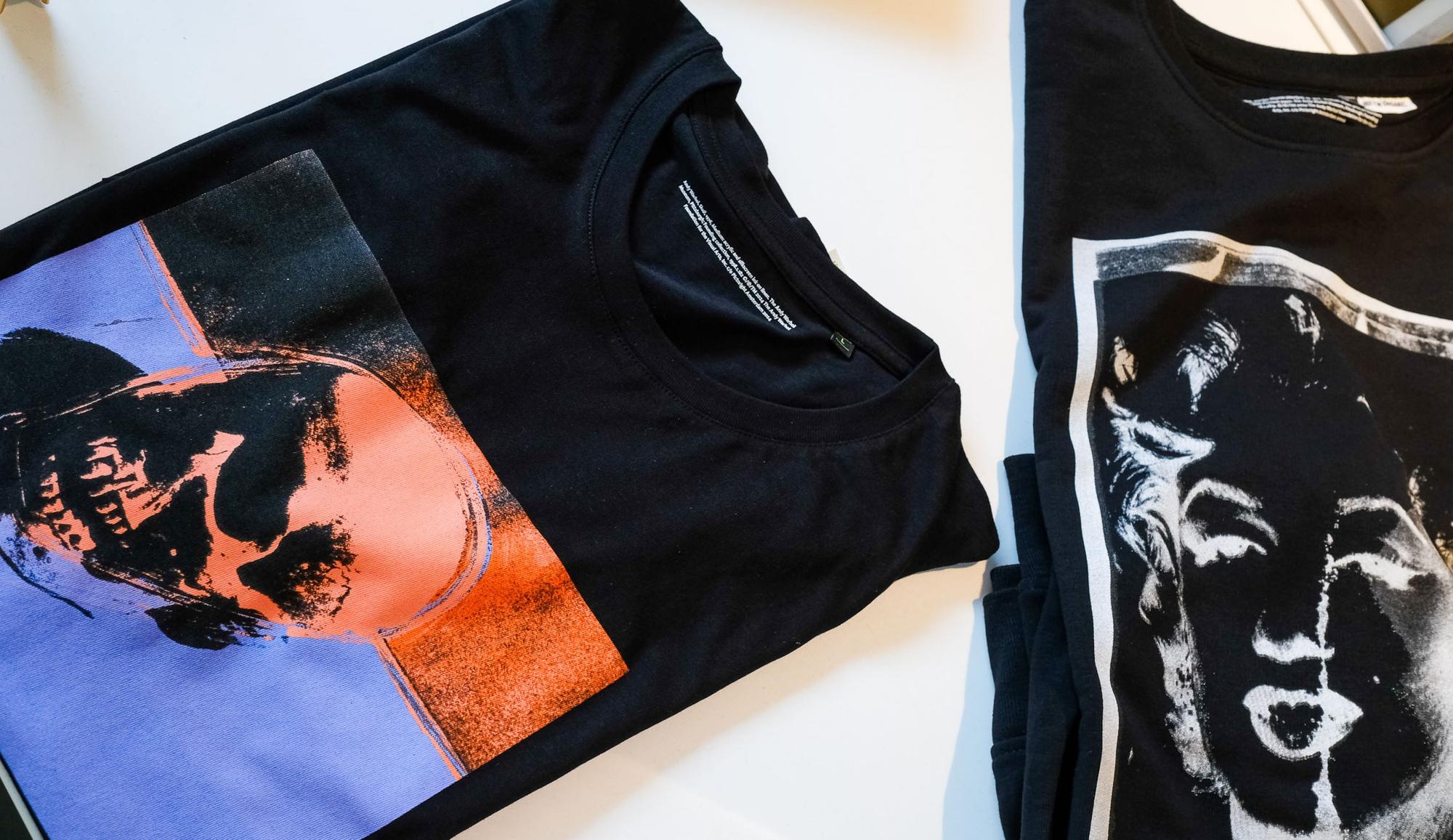 Twee merchandise t-shirts met opdruk van werken uit de expositie Andy Warhol Vanitas.