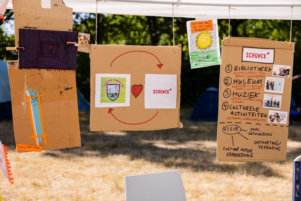 Zelfgemaakte ontwerpen en ideeën voor SCHUNCK en de Buurtcamping hangen aan touwtjes in de tent.