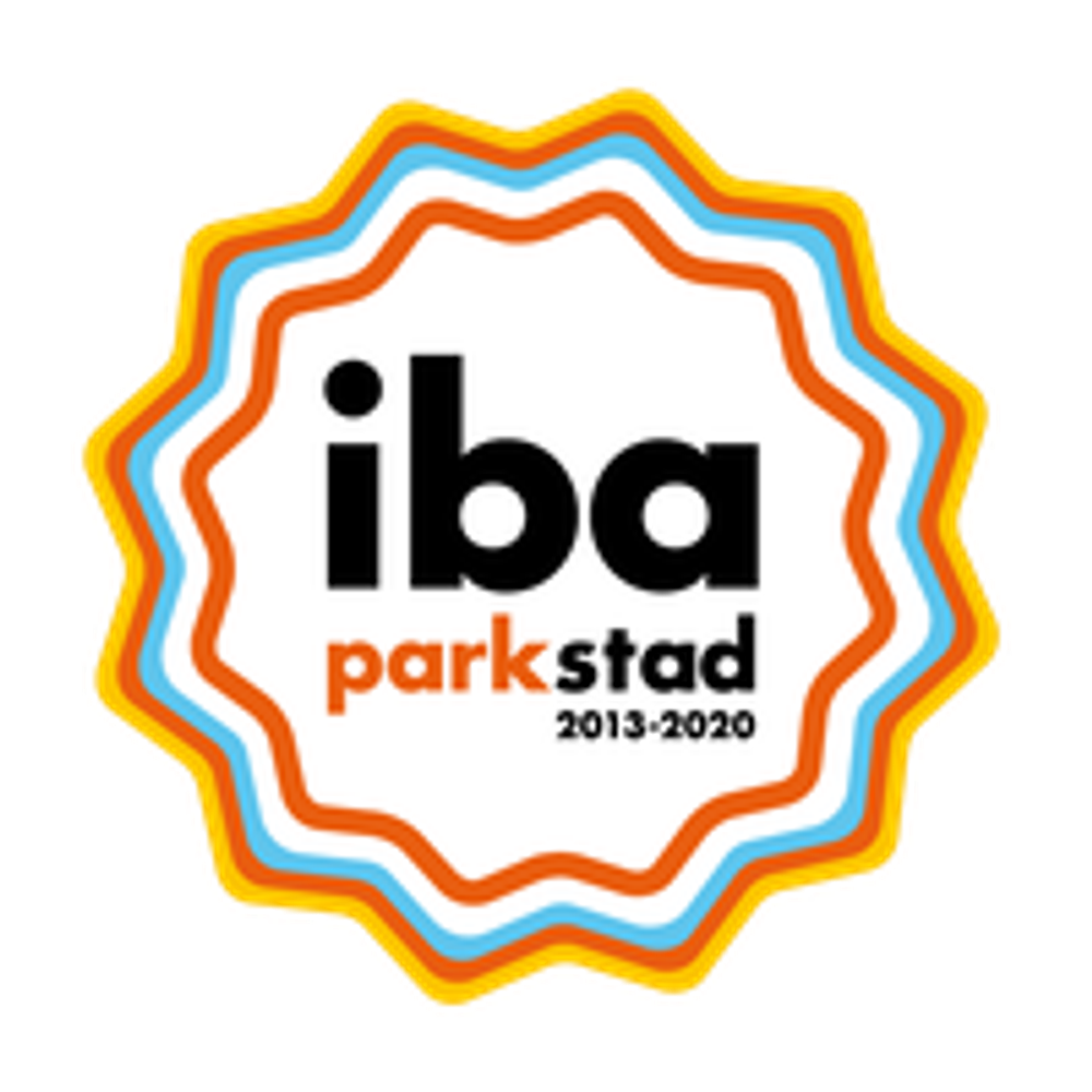 Logo van een sterachtig figuur opgebouwd uit gekleurde lagen in geel, oranje, blauw en wit. In het midden staat zwarte tekst “Iba parkstad”, waarbij het woord “park” in oranje is weergegeven.