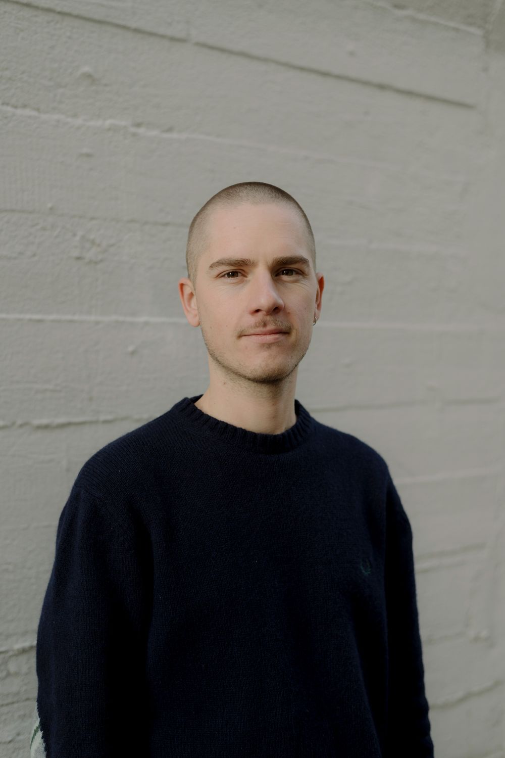 Portretfoto van Robin Vermeulen voor een witte muur.