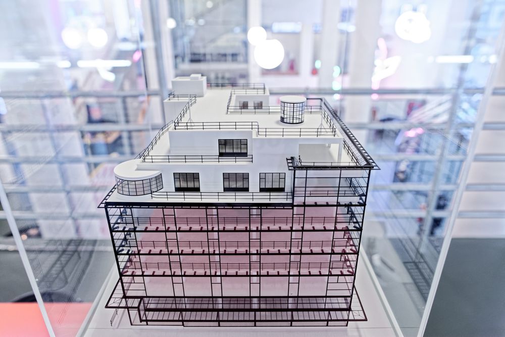 Architectonisch schaalmodel van het Glaspaleis in Heerlen, met gedetailleerde weergave van de modernistische gevel en dakterrassen, tentoongesteld achter glas.