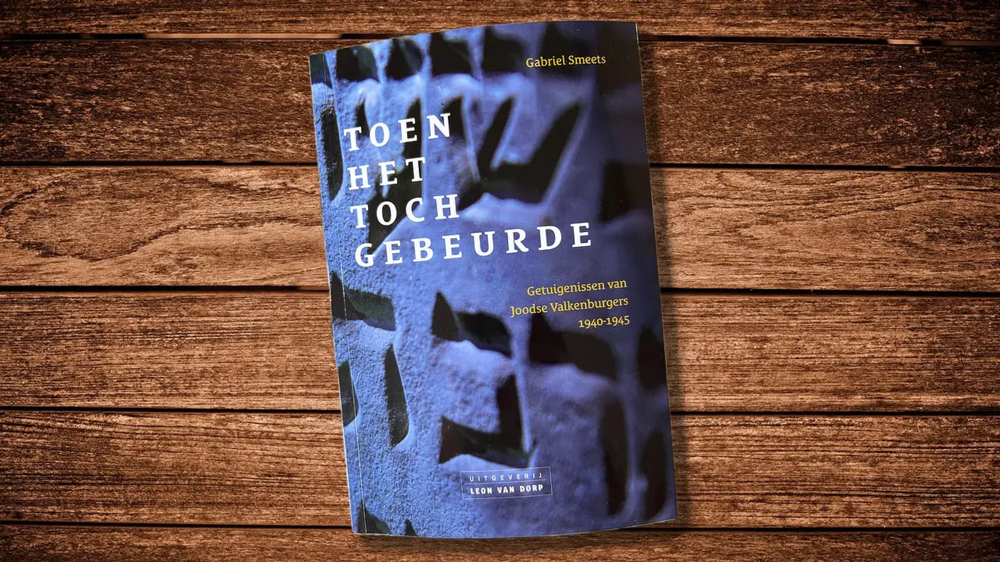 Boek Toen het toch gebeurde van Gabriel Smeets op een houten ondergrond.