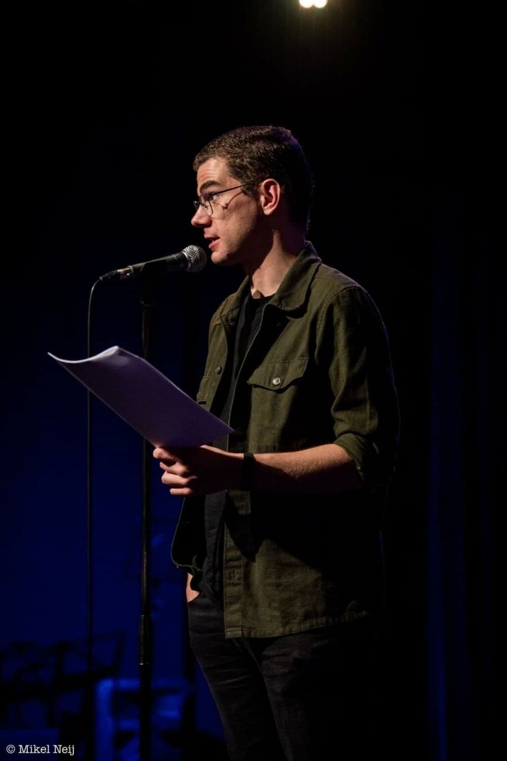 Toon Roumen staat bij een microfoon met papier in zijn hand.