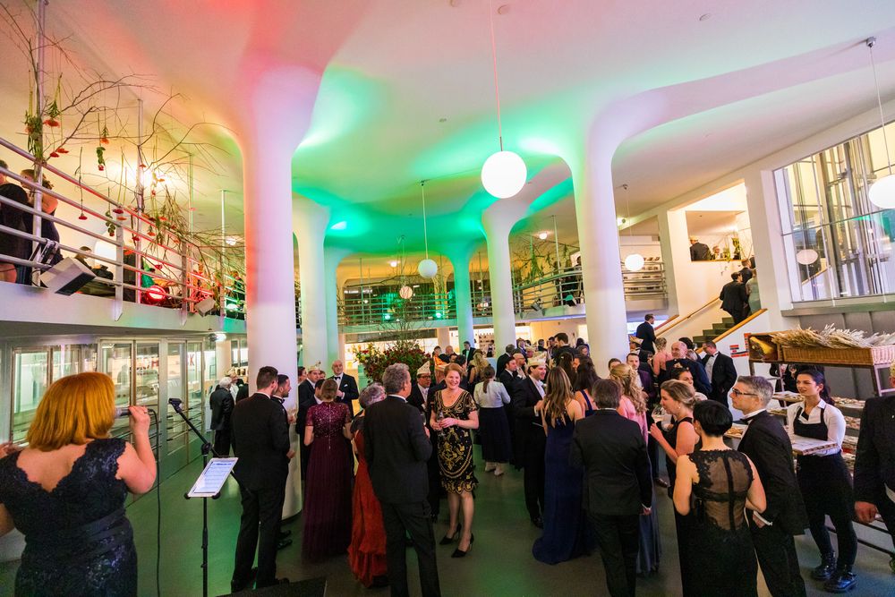 SCHUNCK Glaspaleis iconische vergader en eventlocatie Heerlen - centrale hal. Centrale hal vol mensen in feestkleding tijdens een event.  