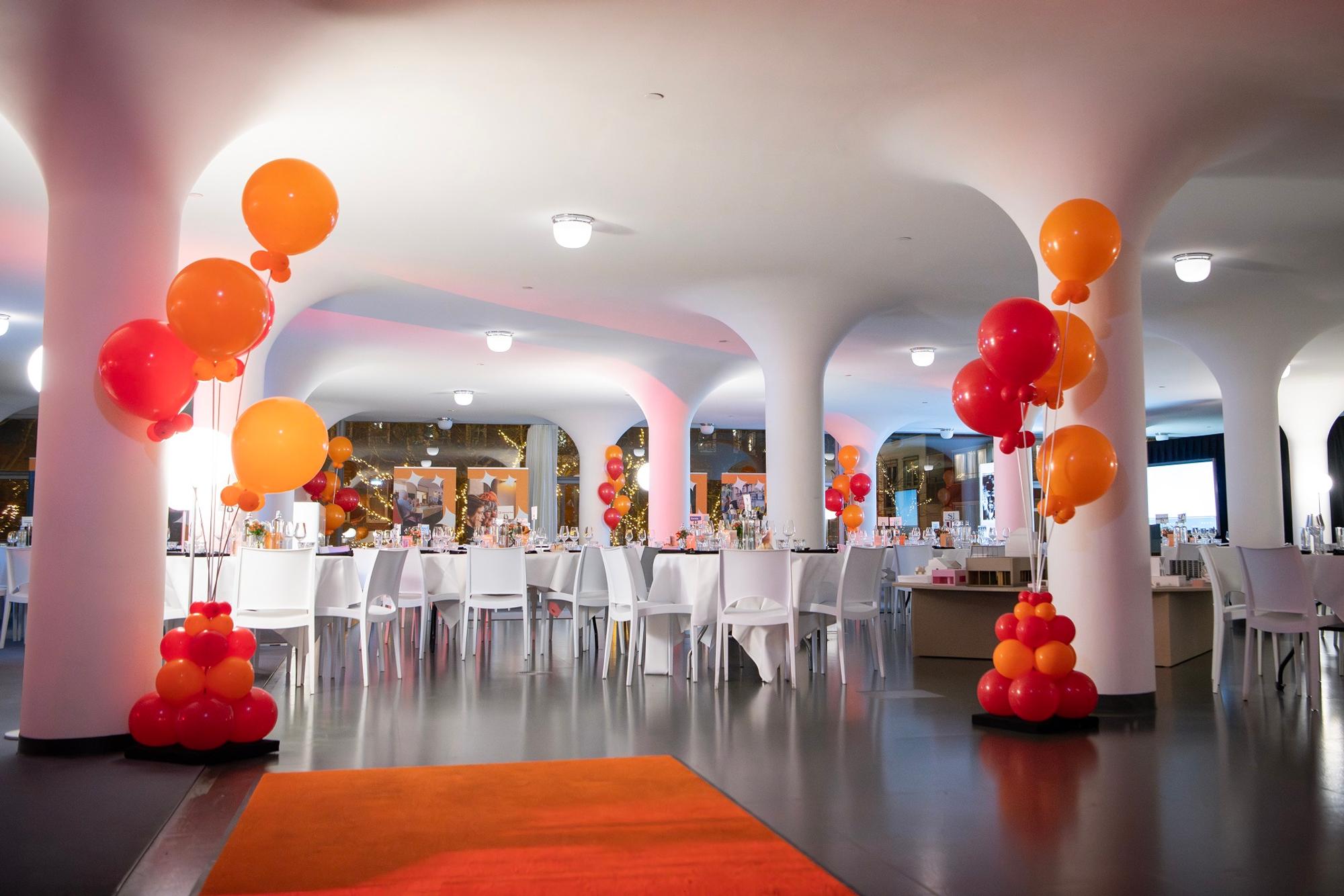 Sfeerimpressie van een event bij SCHUNCK, met stoelen, tafels en oranje ballonnen in de ruimte.