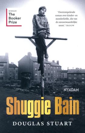 Boekomslag van Shuggie Bain door Douglas Stuart, met een zwart-witfoto van een kind op een houten paal in een vervallen woonwijk. Titel in grote gele letters, onderaan de naam van de auteur. Links een label “Winnaar The Booker Prize” en rechts een citaat van Trouw.