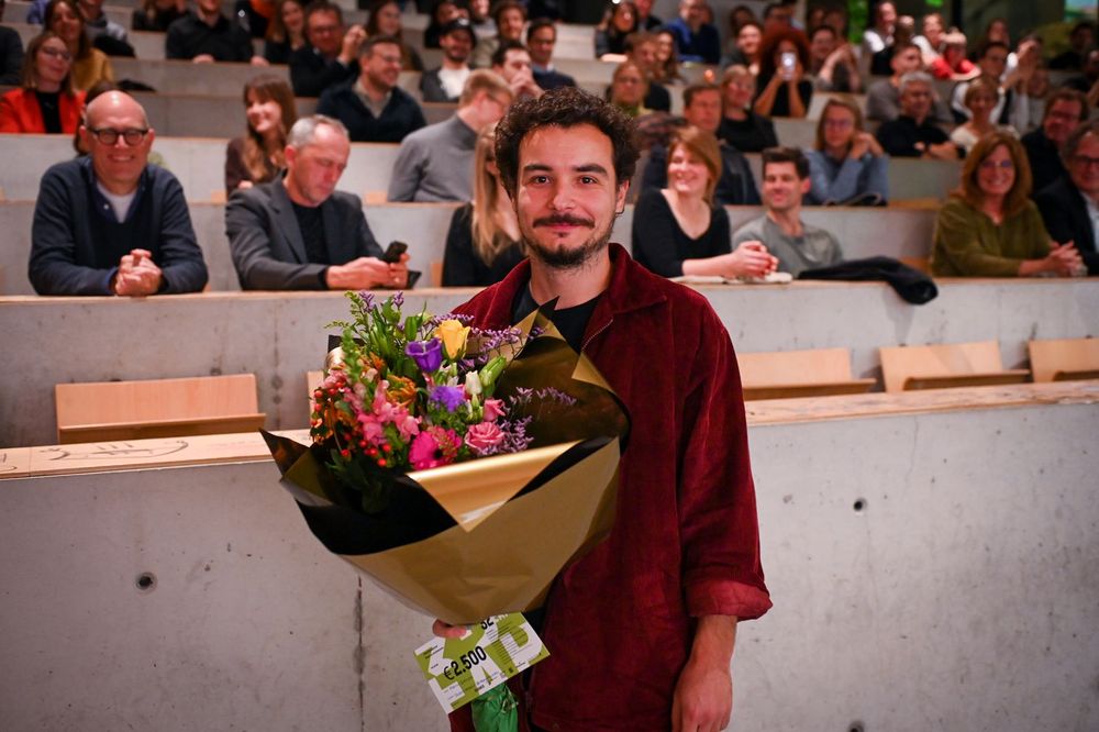 Martin Gjoleka (RWTH Aachen) houdt een bos bloemen vast.