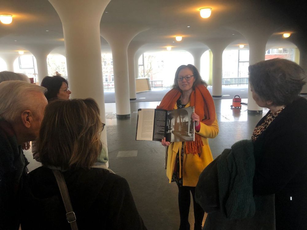Gids Jenny Kranendonk toont historische beelden tijdens een rondleiding door het Glaspaleis van SCHUNCK.