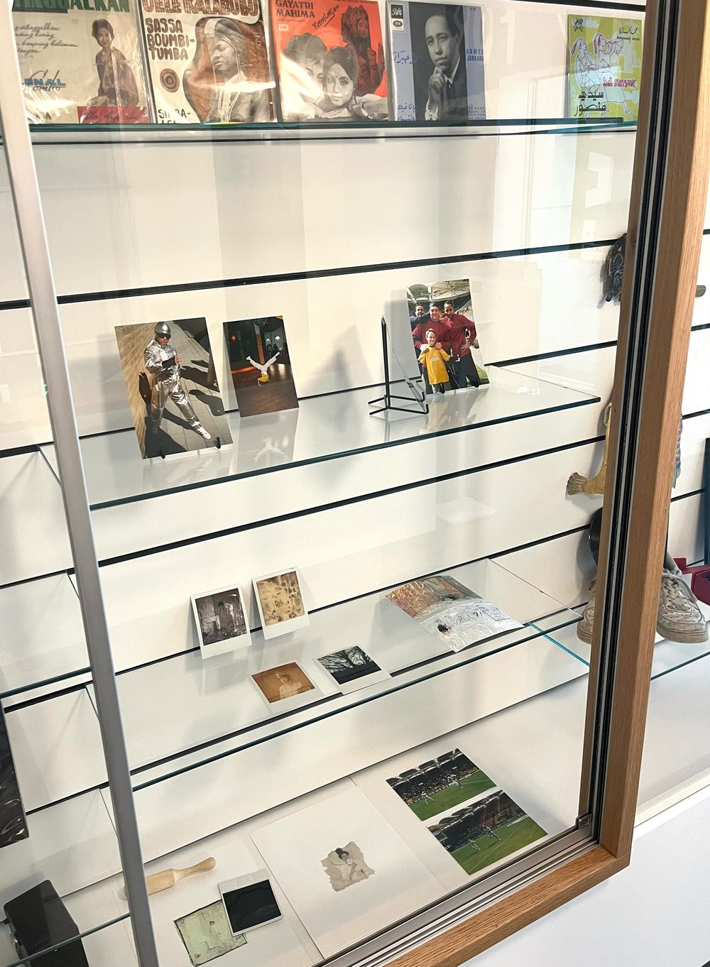 Vitrinekast kabinet met polaroids en foto's tentoongesteld. 