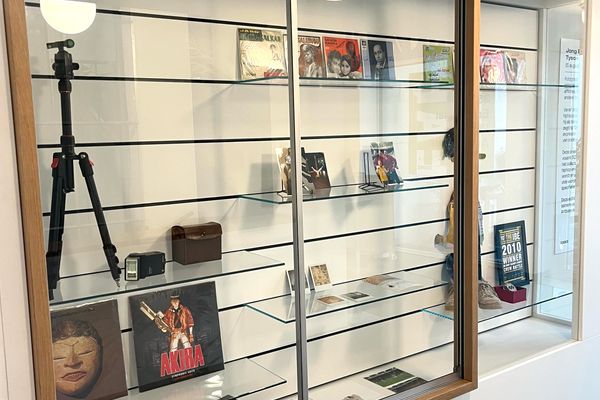 Vitrinekast kabinet met polaroids en foto's tentoongesteld. 