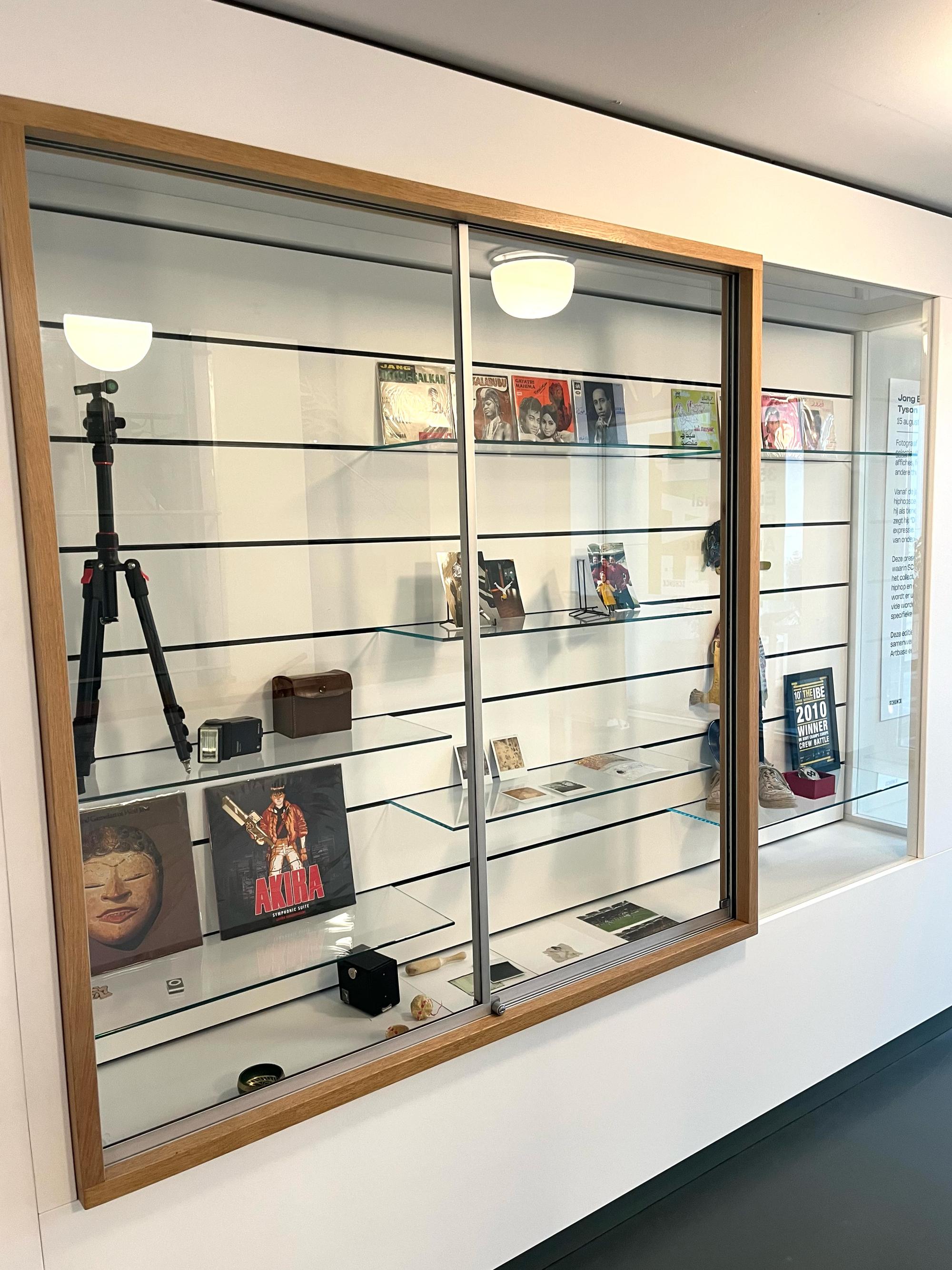 Vitrinekast kabinet met polaroids en foto's tentoongesteld. 