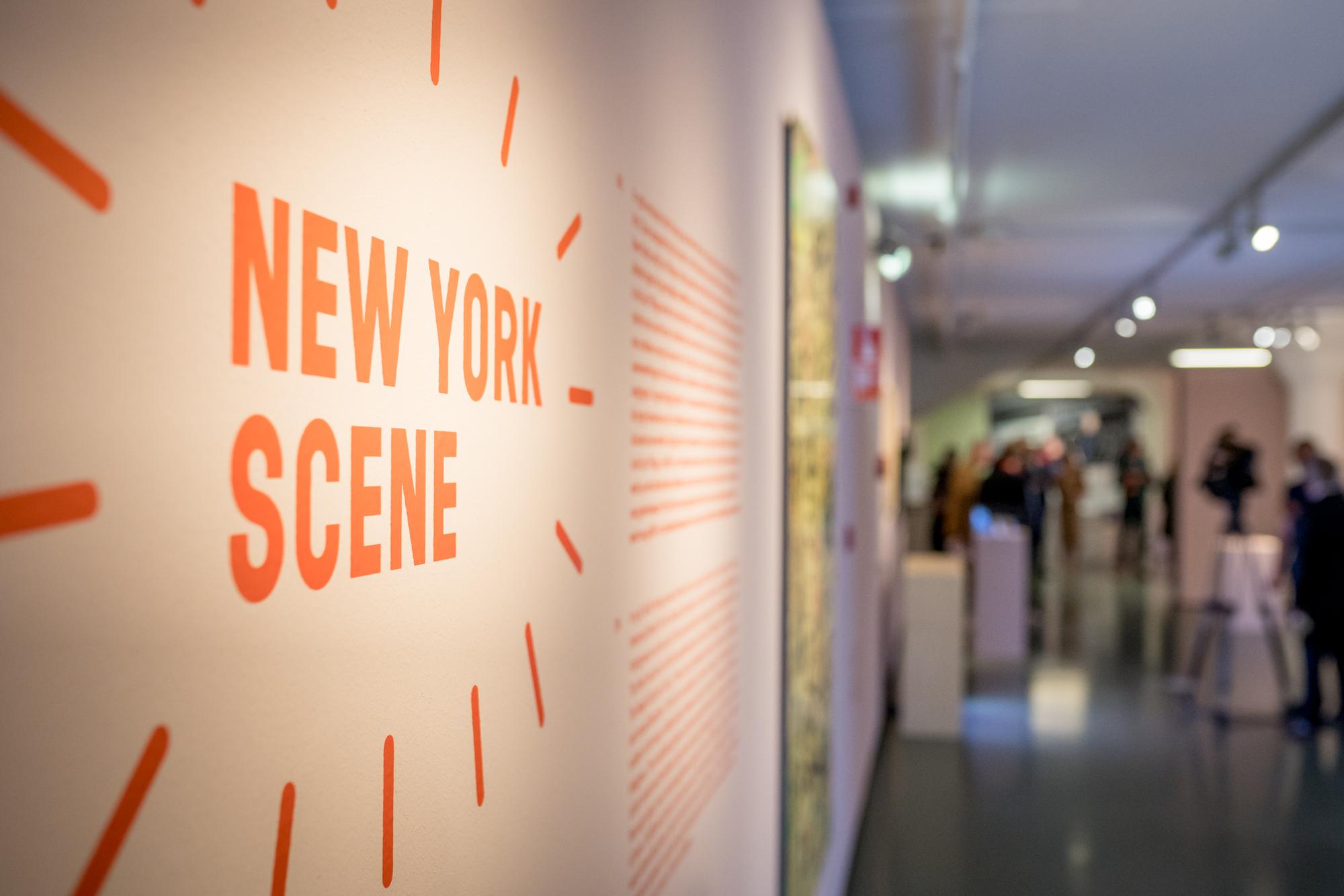 Muur met de titel en zaaltekst van de Keith Haring-expositie.