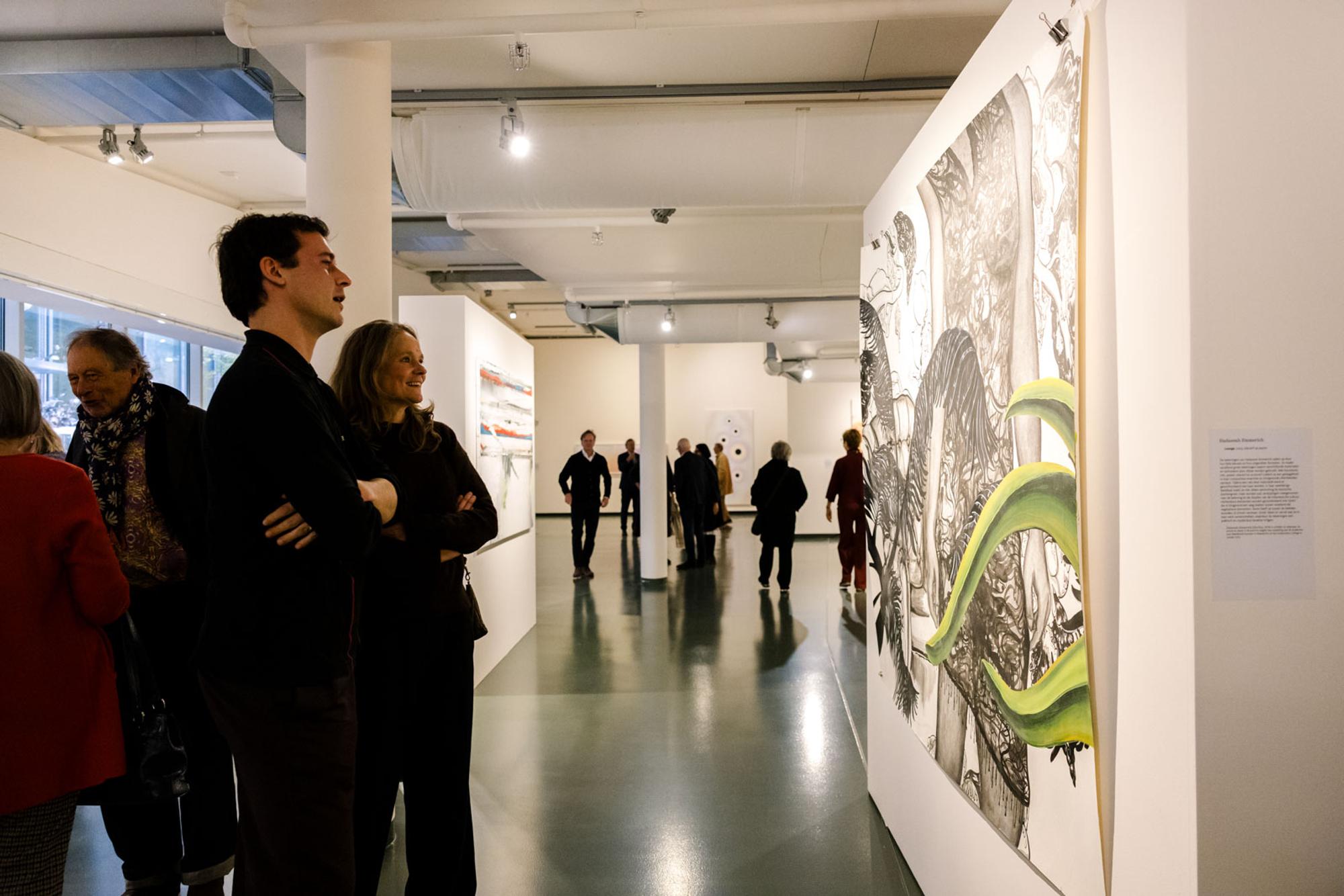 Bezoekers bekijken een kunstwerk in de museumzaal van SCHUNCK tijdens Rooted in Change