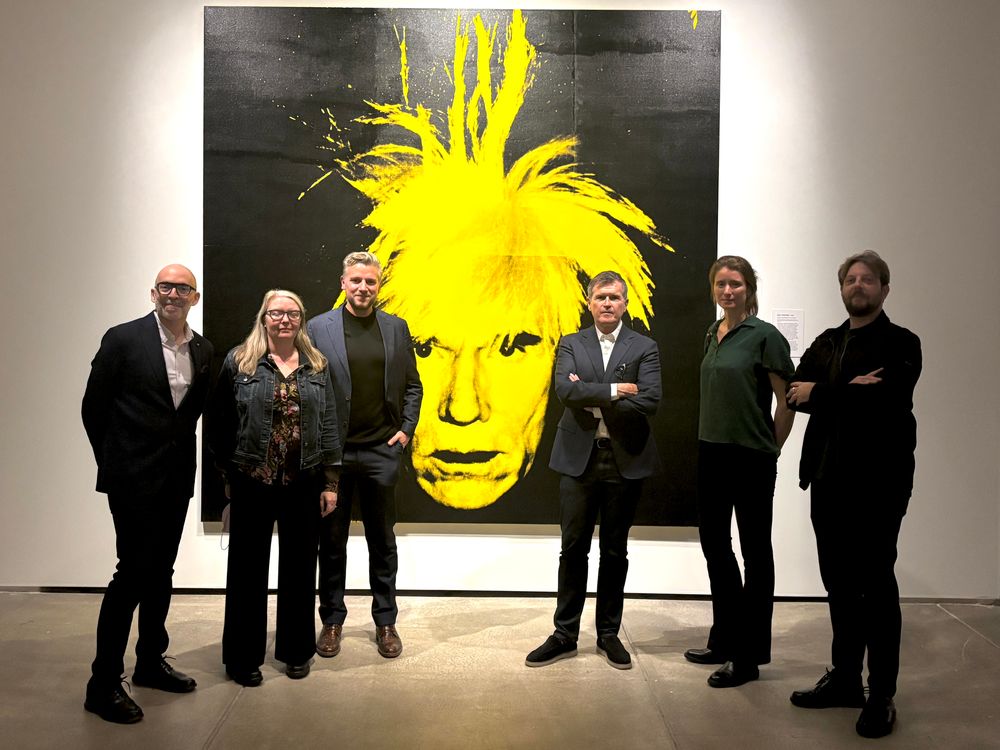 Zes mensen poserend voor een zelfportret van Andy Warhol in The Andy Warhol Museum in Pittsburgh.