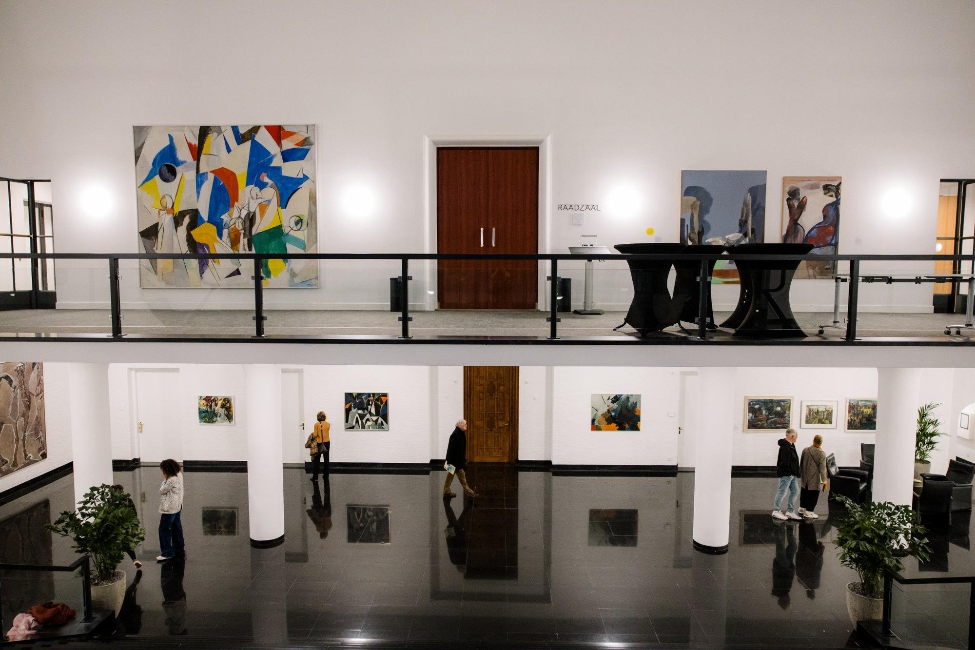 Bezoekers bekijken de kunst in het Raadhuis tijdens Rooted in Change