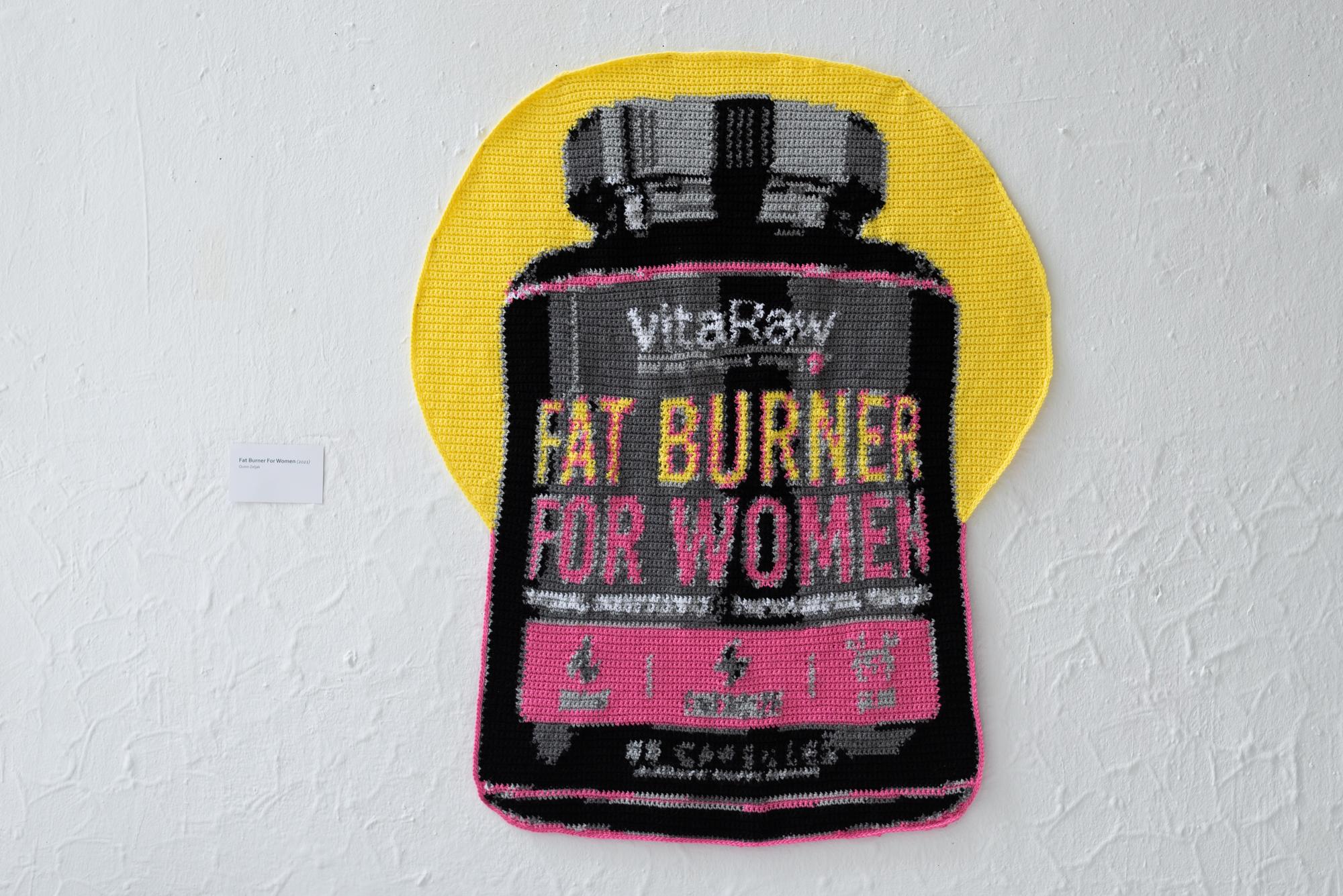 Gehaakt wandkleed in de vorm van een vitaminepotje, met de tekst: "Fat burner for women".