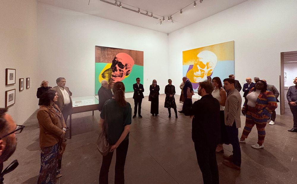 Diverse genodigden in de museumzaal waar verschillende werken van de tentoonstelling Andy Warhol: Vanitas te zien zijn.