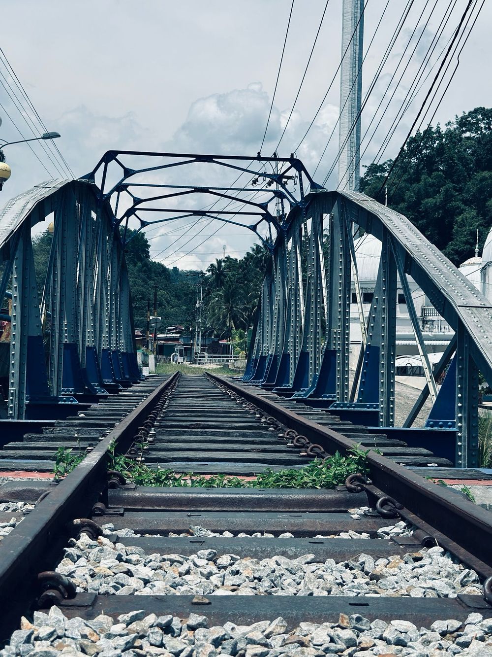 een spoorlijn met wolken en palmbomen op de achtergrond