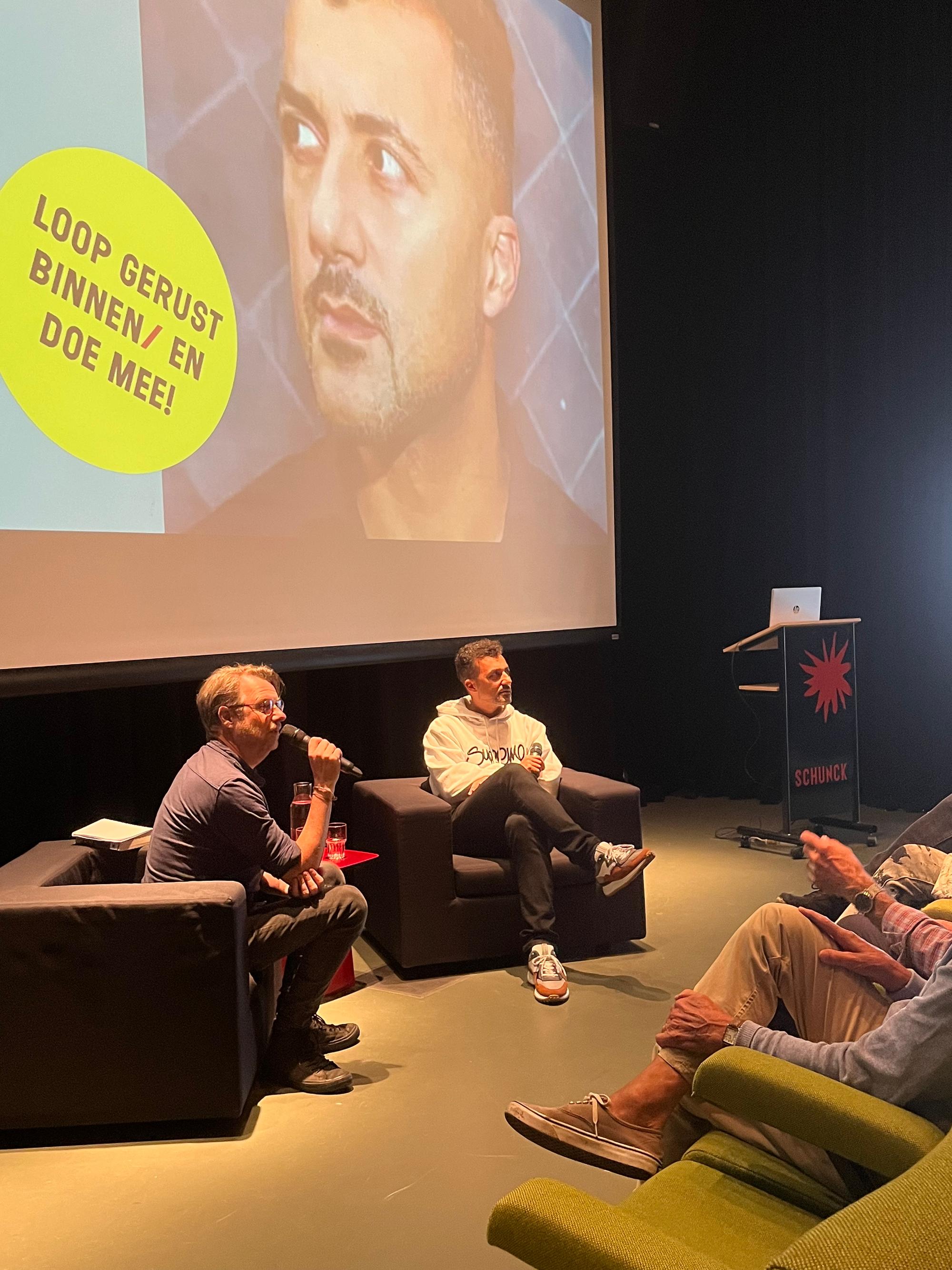Özcan Akyol wordt geïnterviewd in het auditorium van het SCHUNCK Glaspaleis.