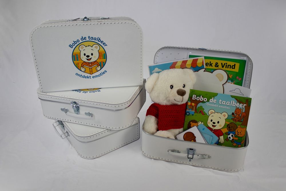 Witte koffertjes met Bobo de taalbeer-logo, open koffertje met knuffelbeer, kinderboeken en kaartjes.