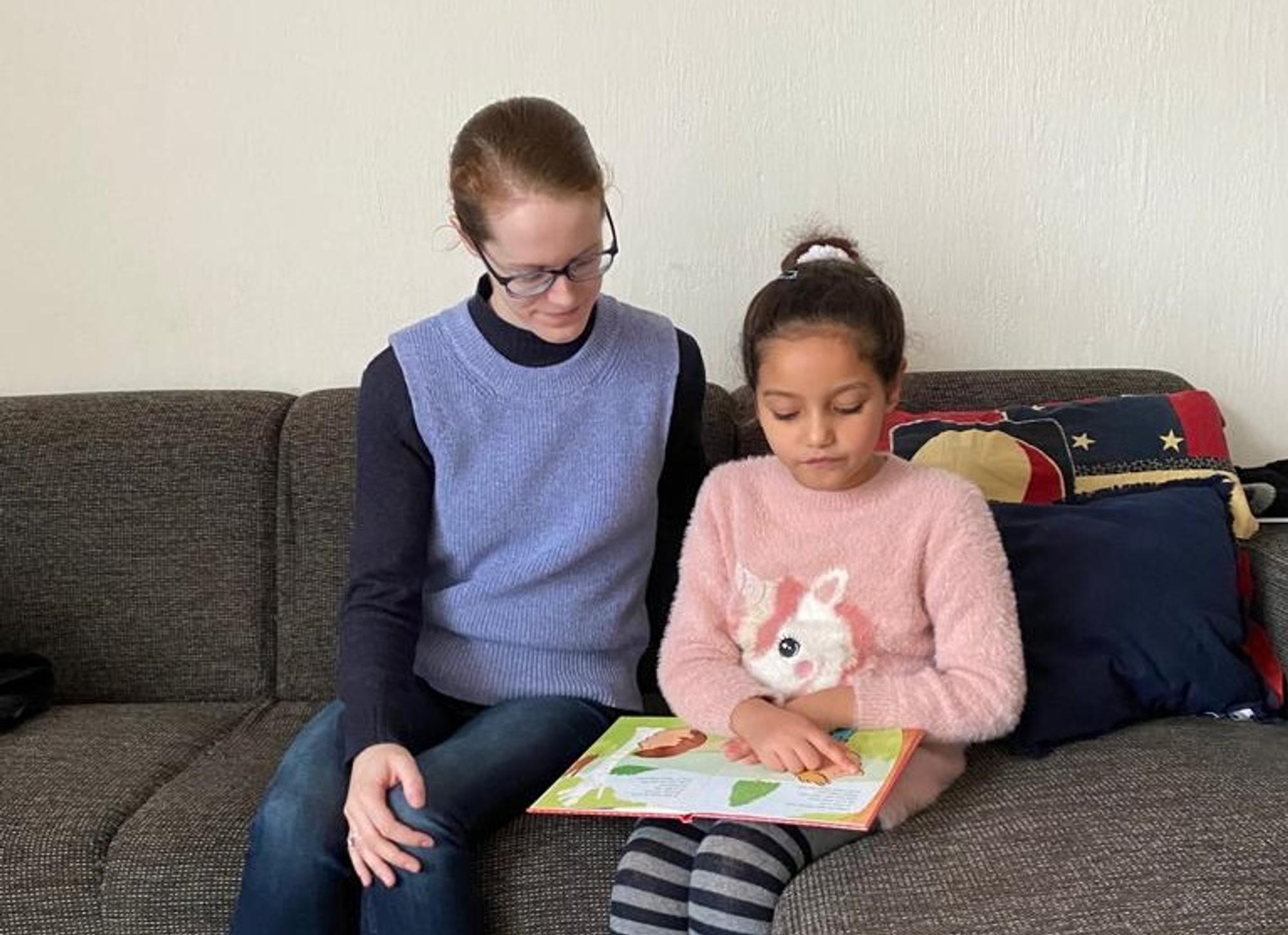 Portret Vrijwilliger Simone Simon Bibliotheek Voorlees Express. Leest voor aan meisje op de bank. 