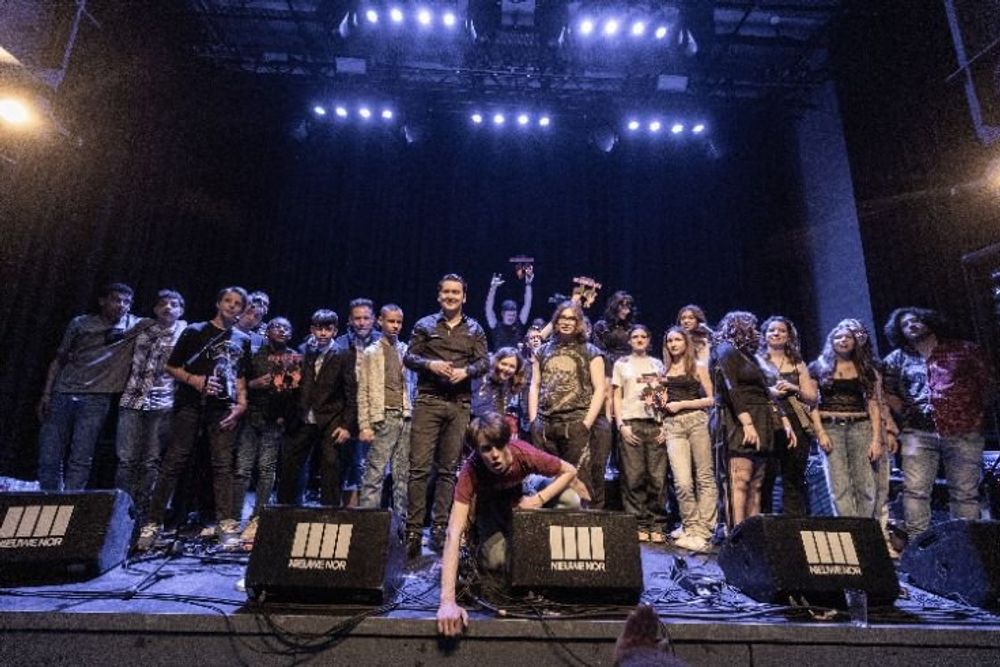 Groepsfoto van deelnemers aan het SCHUNCK High School Band Event 2025 op het podium.