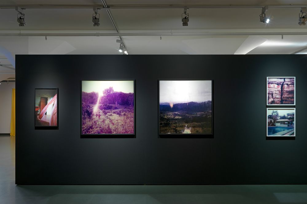 Vijf fotografiewerken van Lara Gasparotto aan een zwarte wand tijdens tentoonstelling Smoke & Mirrors.