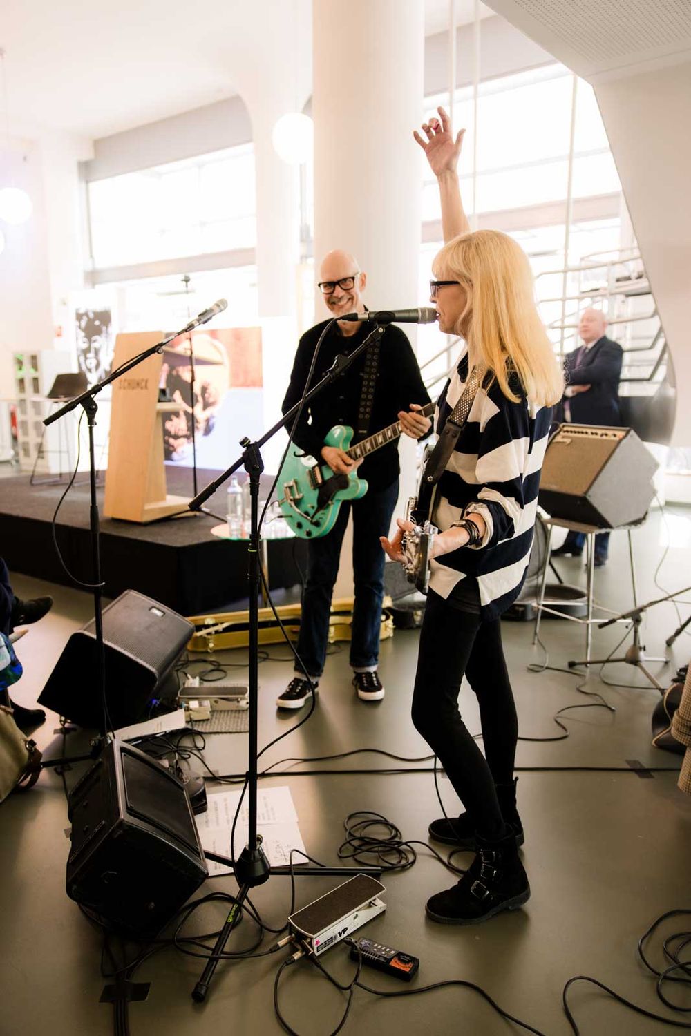 Betty Serveert zingt en speelt gitaar, ze houdt haar arm in de lucht. 