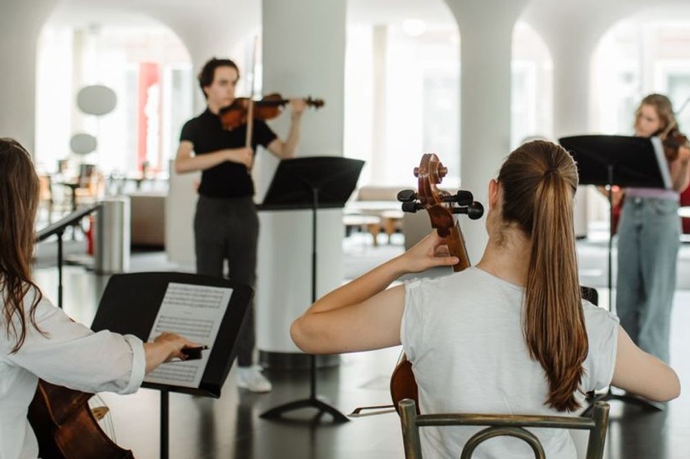 Vier strijkers in een cirkelopstelling maken samen muziek op een verdieping bij SCHUNCK.