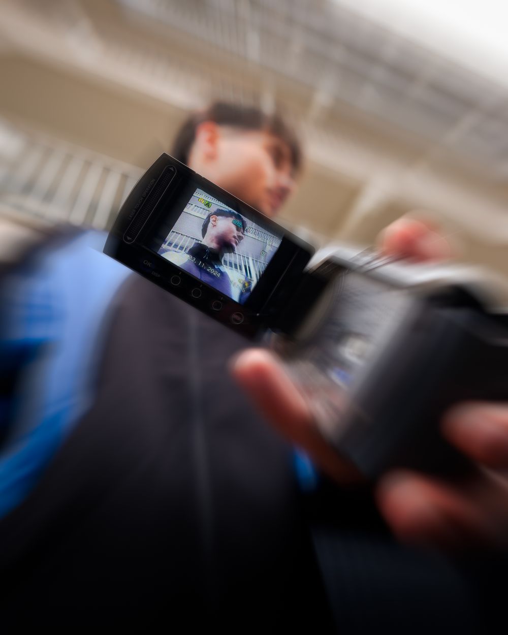 Portret van Miko, vastgelegd door een camrecorder, waarin hij zichzelf fotografeert.