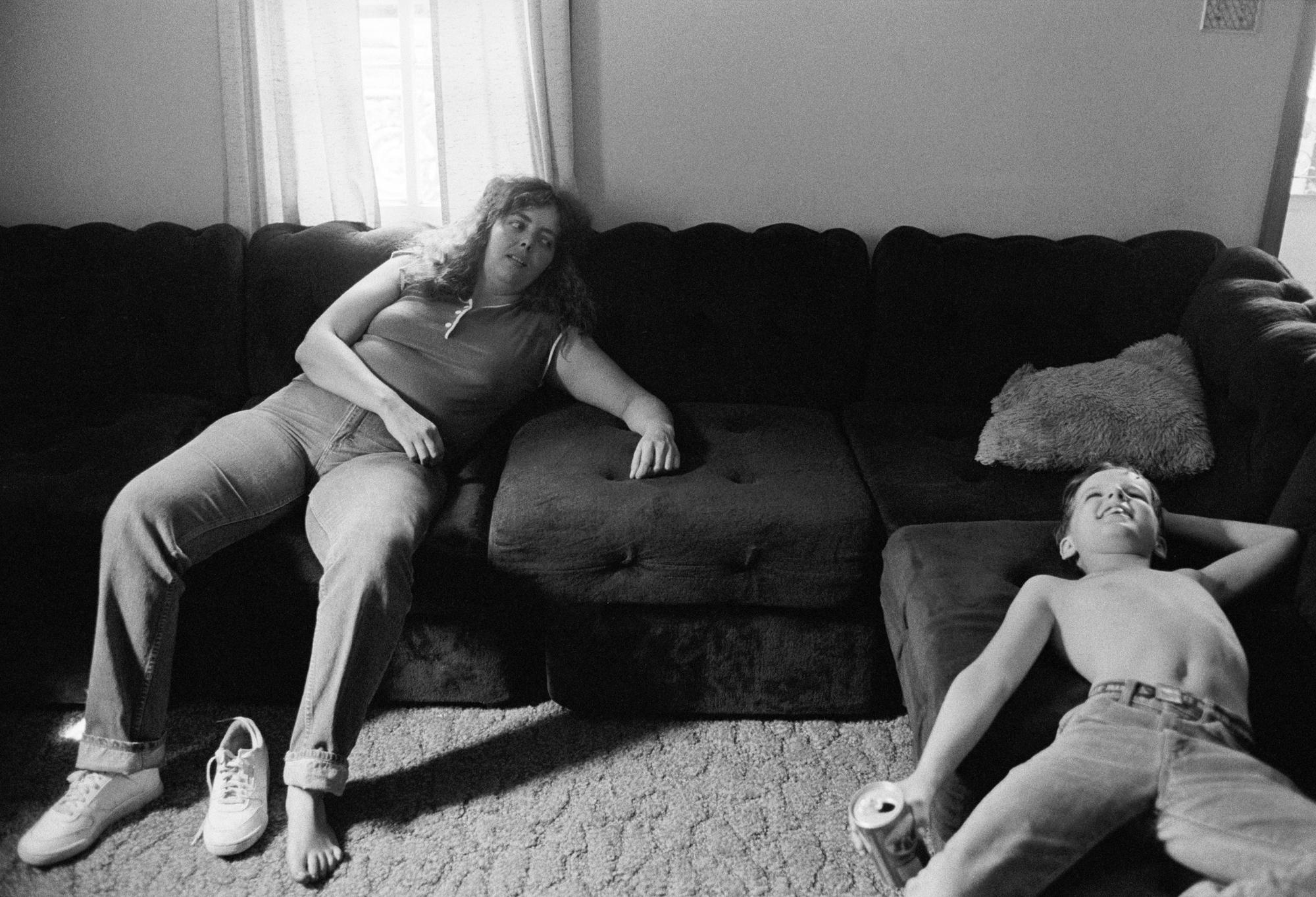 Zwart-wit foto 'David and his Aunt' van Bertien van Manen (1985), West Virginia. Een vrouw en een kind liggen samen op een bank.