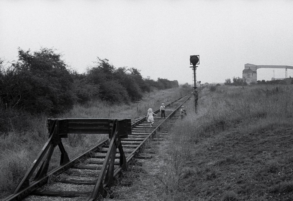 Zwart-witfoto 'New Sharlston' van Bertien van Manen (1979), Yorkshire. Twee kinderen lopen op een treinspoor.