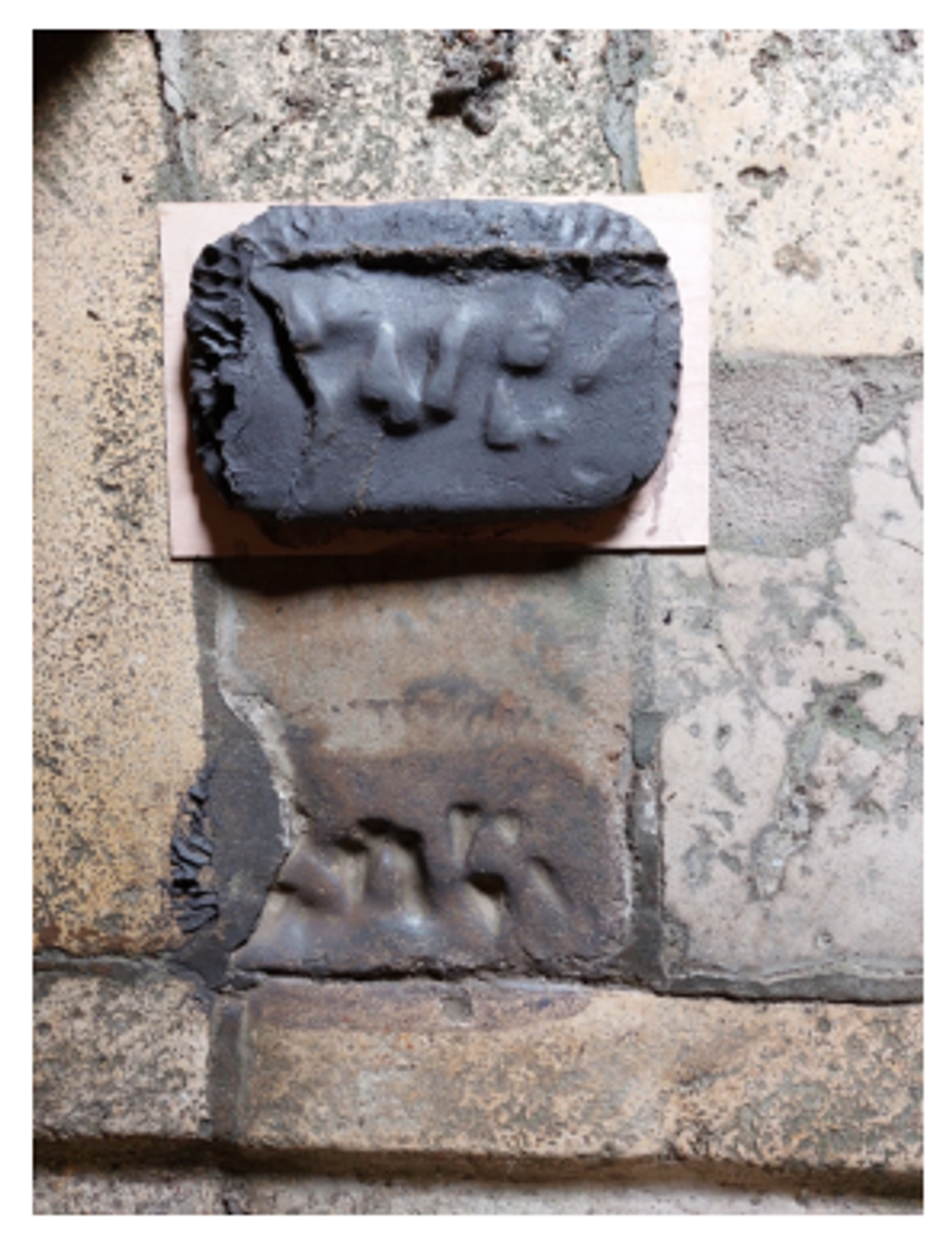 Kleiafdruk van handen in natte klei tijdens het artistieke proces van Charlotte Koenen in een historisch washhuis.