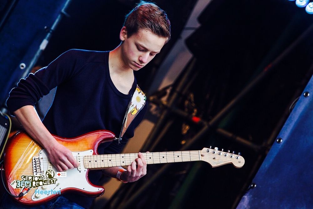 Jongen die een gitaar bespeelt op een podium