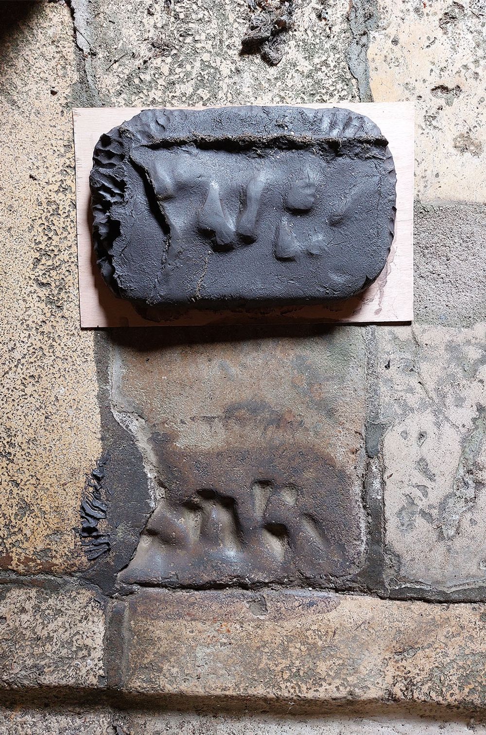 Kleiafdruk van handen in natte klei tijdens het artistieke proces van Charlotte Koenen in een historisch washhuis.