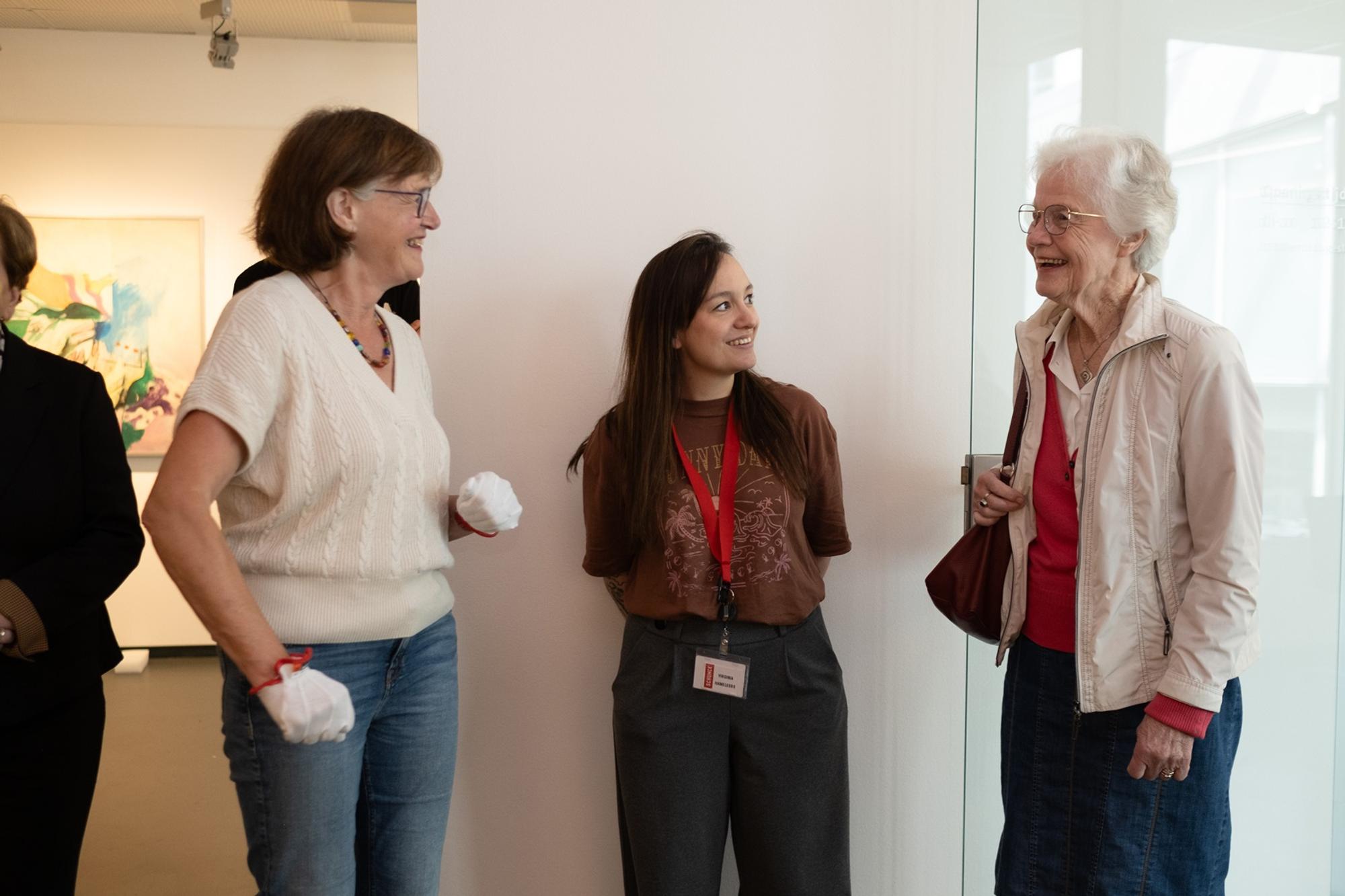 Drie vrouwen die met elkaar praten: een curator, een medewerker van SCHUNCK en een bezoeker.