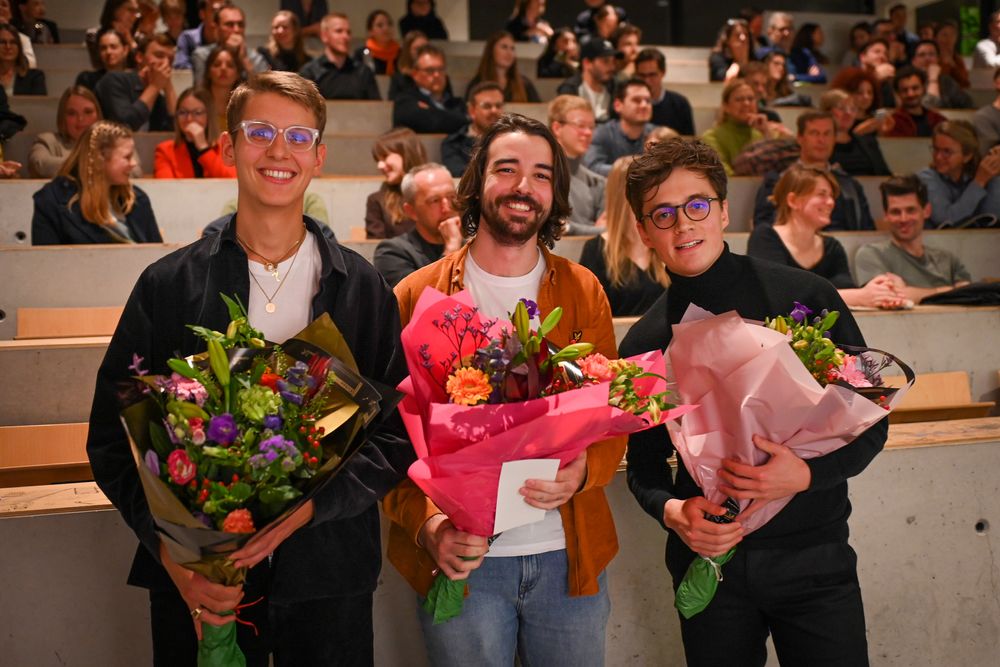 Alexander Collette, Xavier De Lanève en Adrien Vanwerst (ULG Luik) houden een bos bloemen vast.