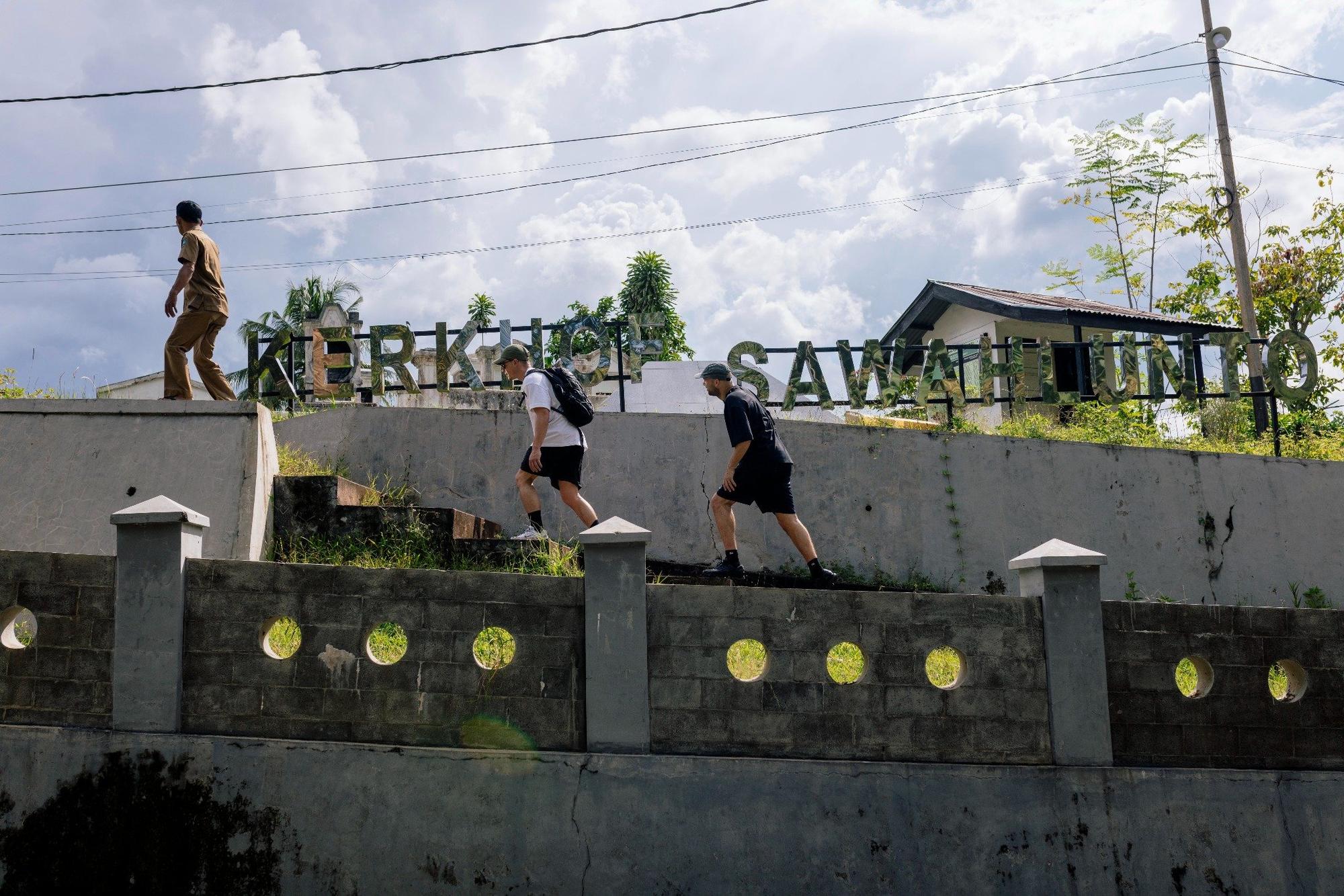 Jop Vermeesch onderzoekt de voormalige mijnstad Sawahlunto, lopend langs het bord met de tekst ‘Kerkhof Sawahlunto’.