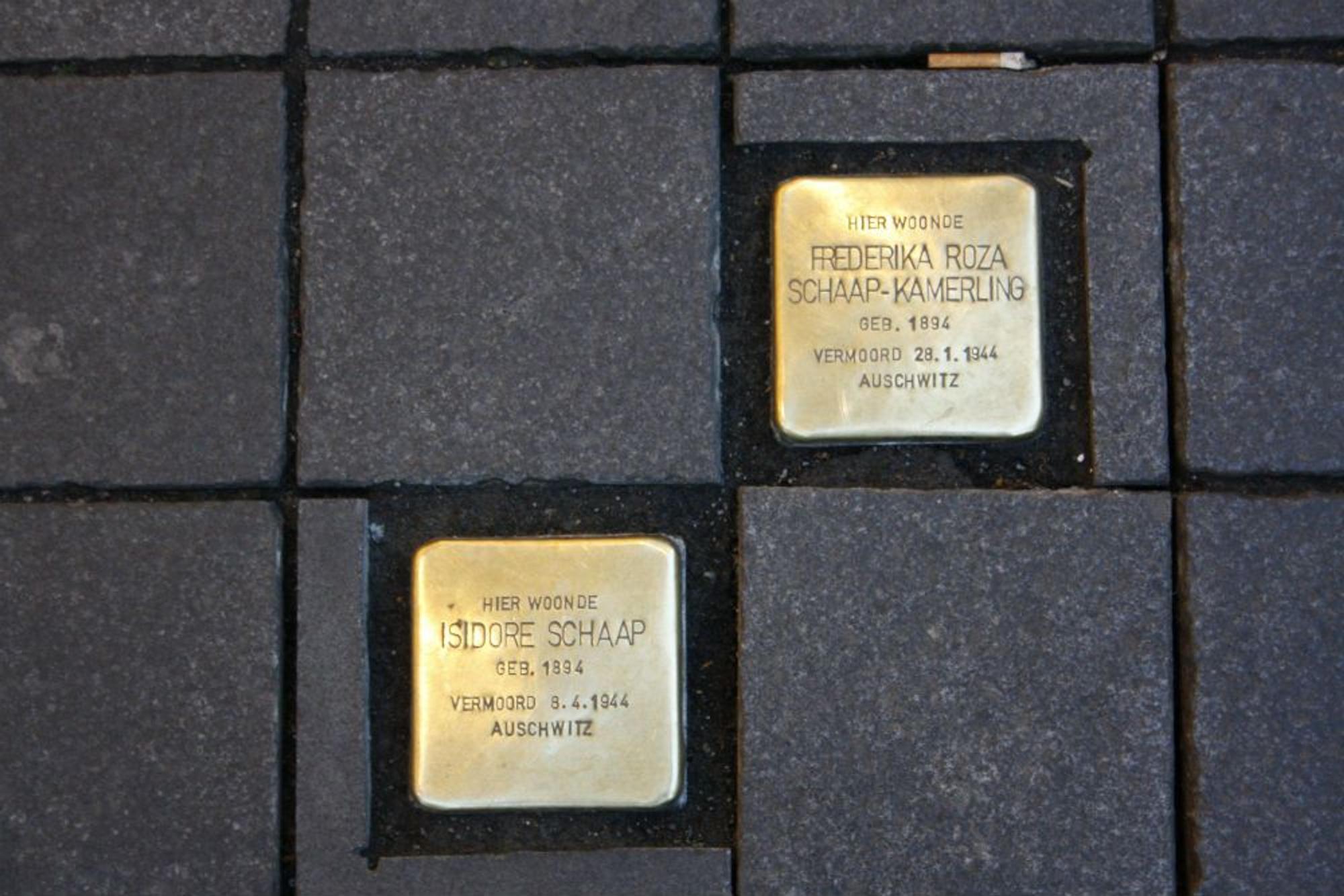 Twee Stolpersteinen/ struikelstenen met namen: 'Isodore Schaap' en 'Frederika Roza Schaap-Kamerling'.