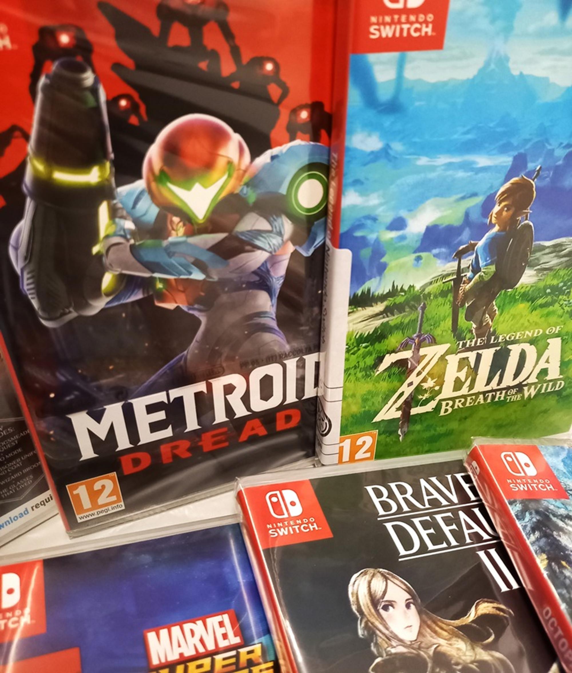 Nintendo Switch-games tentoongesteld in een boekenkast, waaronder Metroid Dread, The Legend of Zelda: Breath of the Wild, Bravely Default II en Marvel Super Heroes.